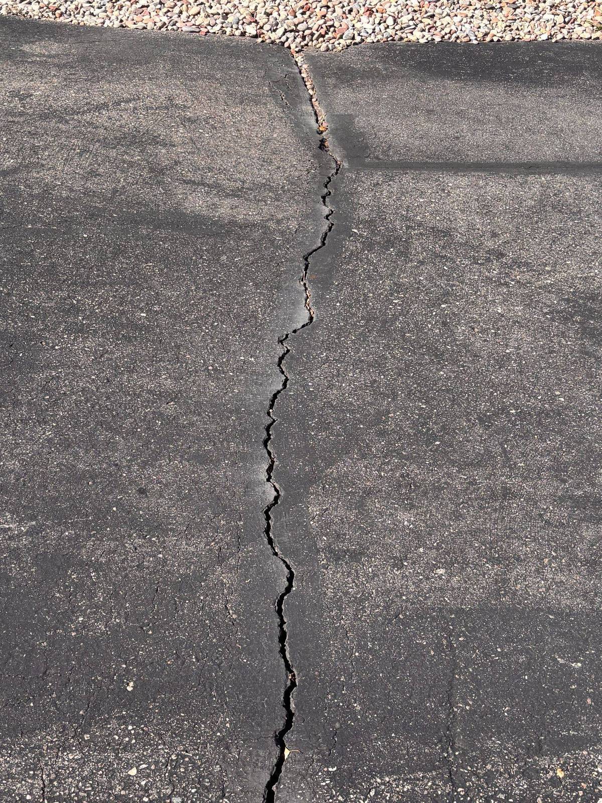 A long crack running the length of a driveway